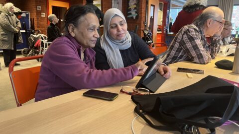 man and woman sitting with ipad